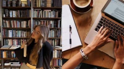Person with book in library and hands typing on laptop with coffee on a wooden desk, blending study and work.