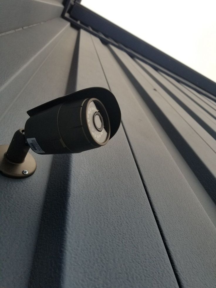 Security camera mounted on a metal wall for outdoor surveillance and protection.