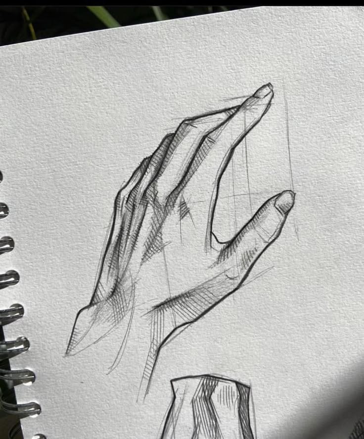 Detailed pencil sketch of a hand on spiral notebook paper, showcasing intricate shading and anatomy.