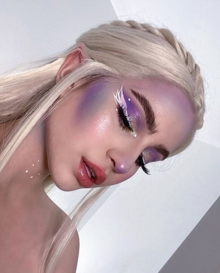 abby ☆ Woman with shimmering purple makeup and braided blonde hair, showcasing vibrant fantasy look. | Sky Rye Design Woman with shimmering purple makeup and braided blonde hair, showcasing vibrant fantasy look.