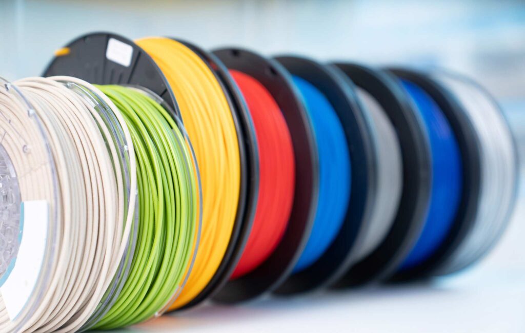 Colorful 3D printer filament spools in a row, showcasing variety for creative projects and printing.