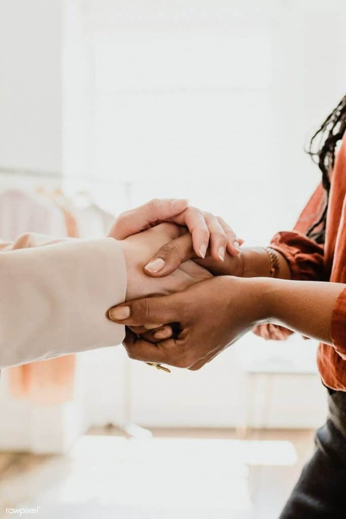 Two people shaking hands warmly, symbolizing trust and partnership in a bright, welcoming environment.