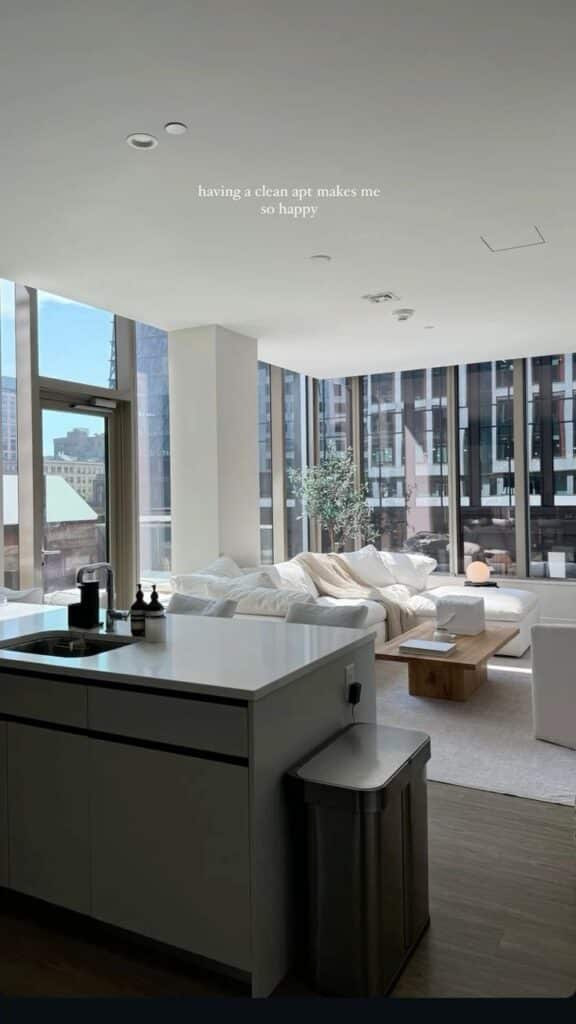 Modern, sunlit apartment with clean kitchen and cozy living room, highlighting urban living and relaxation.