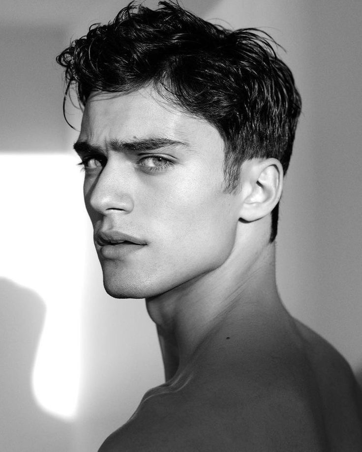 Black and white portrait of a man looking over his shoulder with a serious expression.