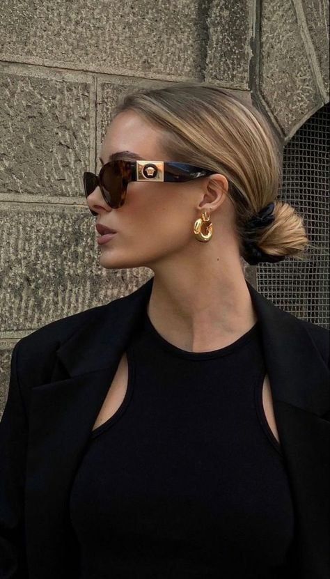 boss woman Stylish woman in sunglasses, gold earrings, and a black outfit against a textured wall background. | Sky Rye Design Stylish woman in sunglasses, gold earrings, and a black outfit against a textured wall background.