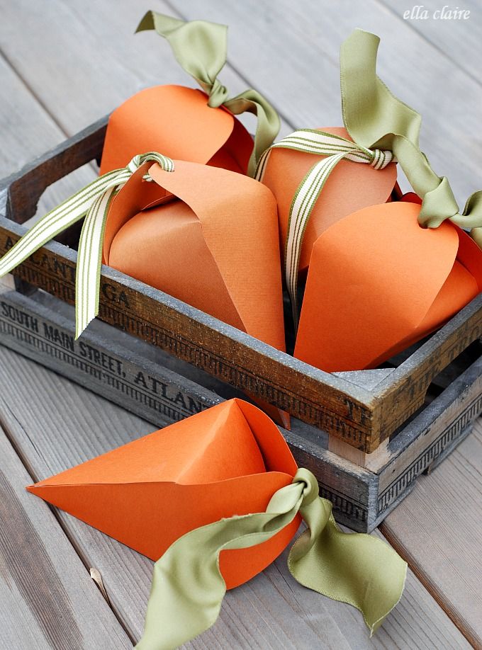 c0c311c2c53e6f50316261ae7fff1401 Orange paper carrot-shaped gift boxes in a wooden crate, tied with green ribbon, on a wooden surface. | Sky Rye Design Orange paper carrot-shaped gift boxes in a wooden crate, tied with green ribbon, on a wooden surface.