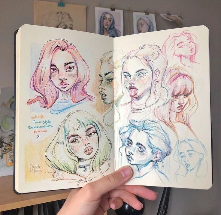 Sketchbook with colorful portraits of people, showcasing diverse styles and expressions in pencil and pastel.