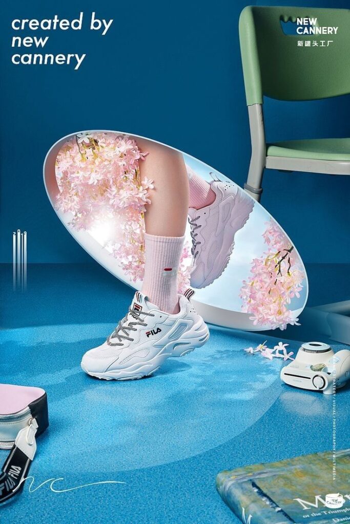 White sneaker near mirror reflecting cherry blossoms, with pink socks and a green chair in the background.