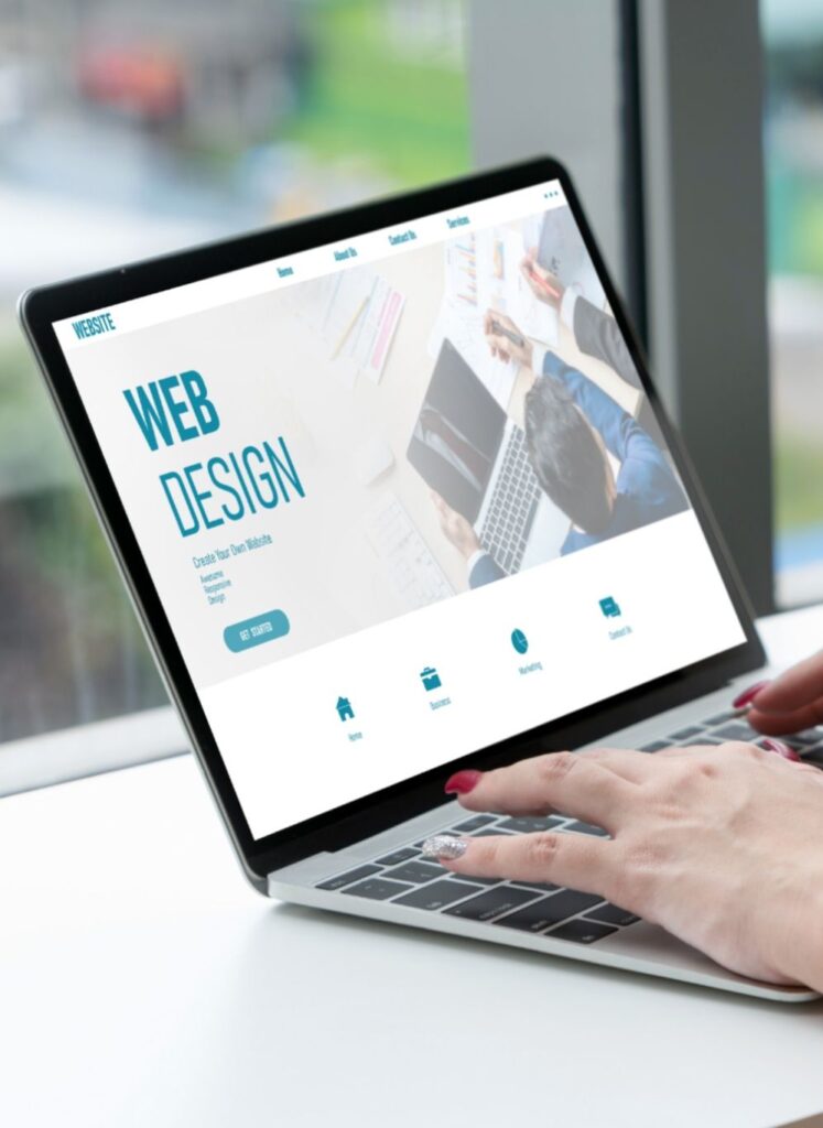 Person using laptop for web design with a website creation interface on screen.