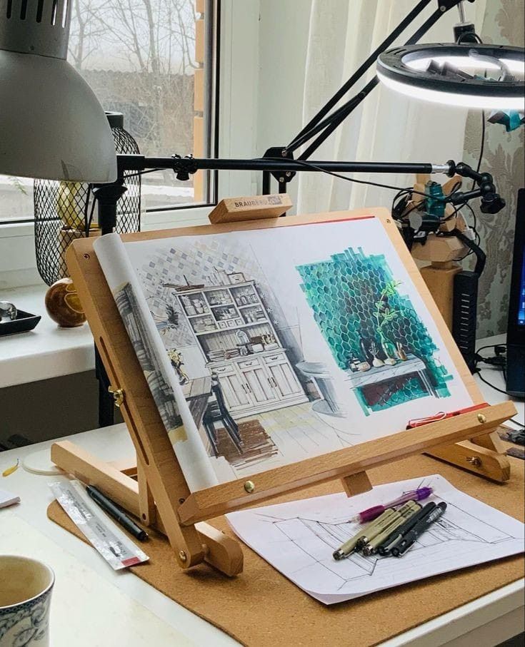 Architectural sketch on an easel by window, with pens and desk lamp, capturing a detailed interior scene.