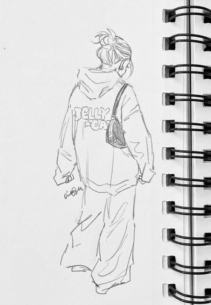Sketch of a person in a Jellycat hoodie with a bun hairstyle, seen from behind, in a notebook.