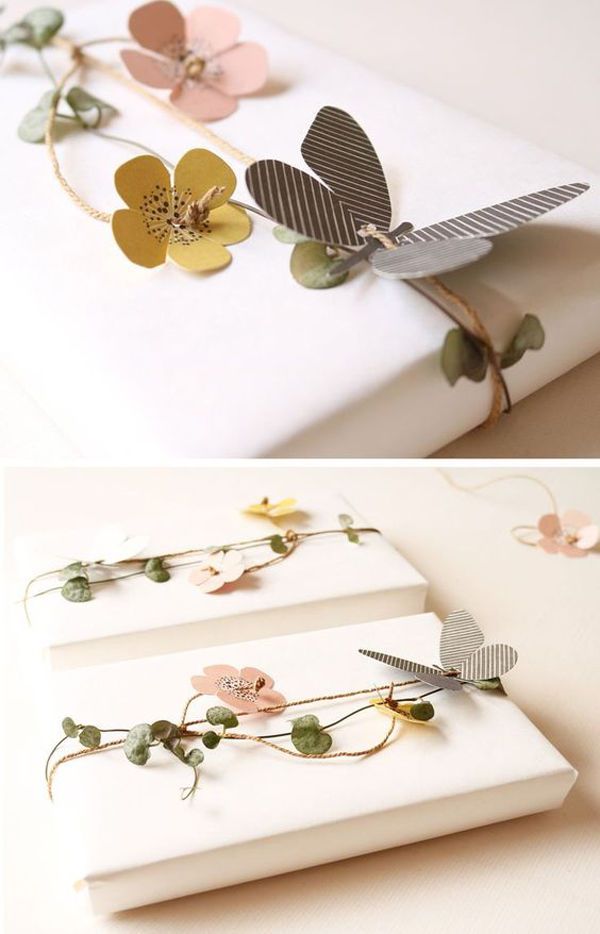 Beautifully wrapped gifts with paper flowers and butterfly decoration, perfect for elegant and stylish presentation.