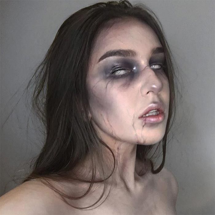 Spooky makeup with dark shadows and white lenses for a haunting Halloween look.