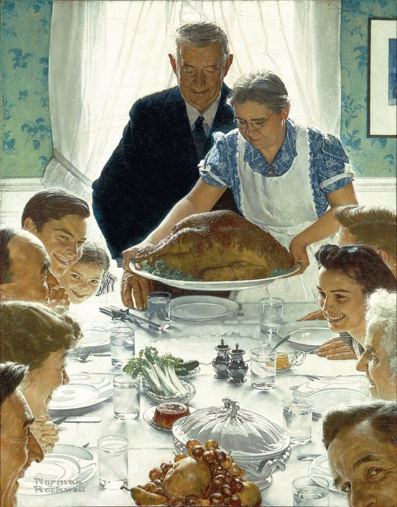 Family gathered around a table for a festive holiday meal, featuring a large turkey being served.