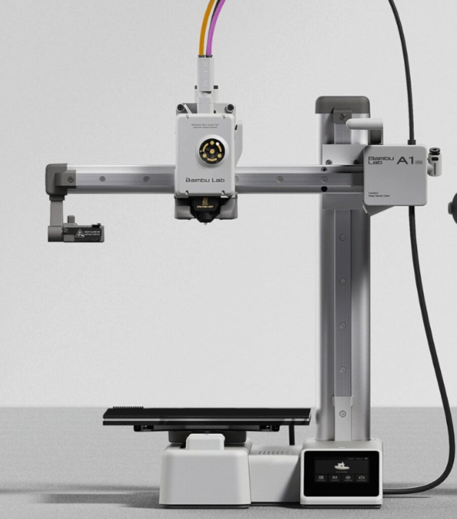 Bambu Lab A1 3D printer on a gray surface, featuring advanced extrusion technology and precision tools.