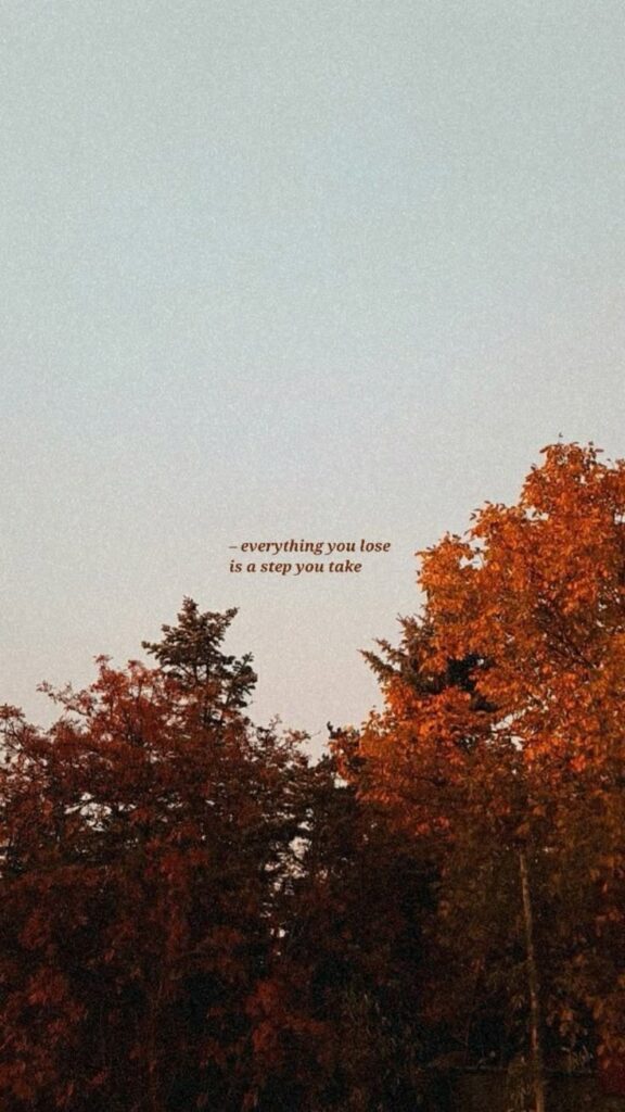 Autumn trees and sky with motivational quote: Everything you lose is a step you take.