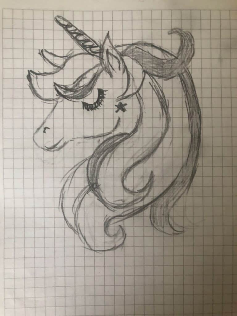 Hand-drawn unicorn sketch with flowing mane and closed eyes on a grid paper background.