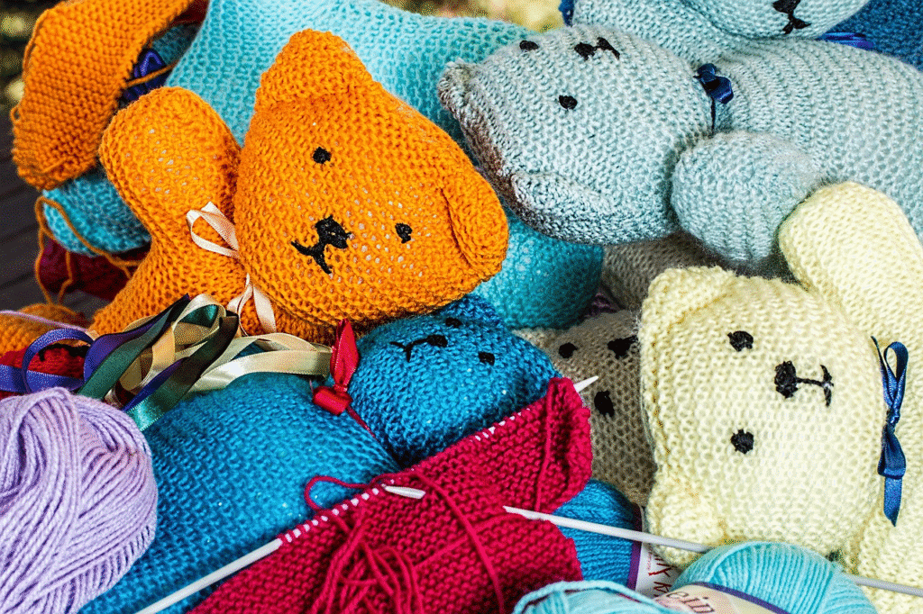image Colorful knitted teddy bears with yarn and knitting needles, showcasing a handmade craft collection. | Sky Rye Design Colorful knitted teddy bears with yarn and knitting needles, showcasing a handmade craft collection.