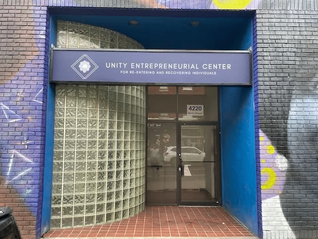 image Entrance to Unity Entrepreneurial Center on Main Street, featuring modern glass block design and colorful mural. | Sky Rye Design Entrance to Unity Entrepreneurial Center on Main Street, featuring modern glass block design and colorful mural.