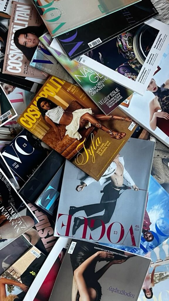 Pile of fashion magazines showcasing colorful covers and diverse photography.