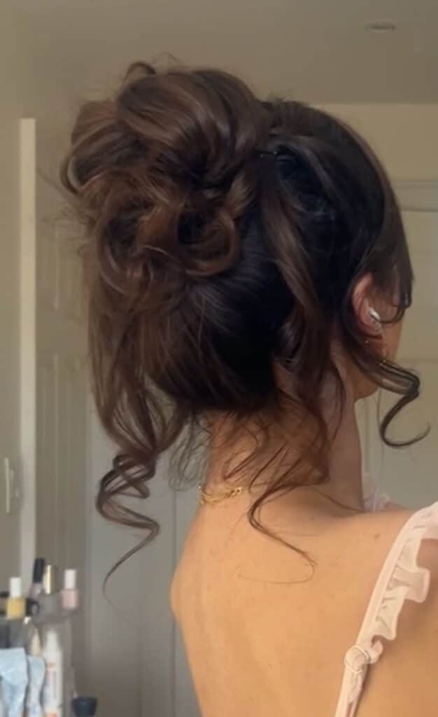 Elegant messy bun hairstyle with loose curls.