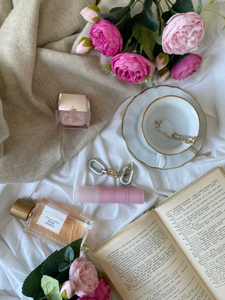 mobilephotography iphonephotography Flat lay with pink flowers, skincare products, a teacup, and an open book on a cozy beige blanket. | Sky Rye Design Flat lay with pink flowers, skincare products, a teacup, and an open book on a cozy beige blanket.