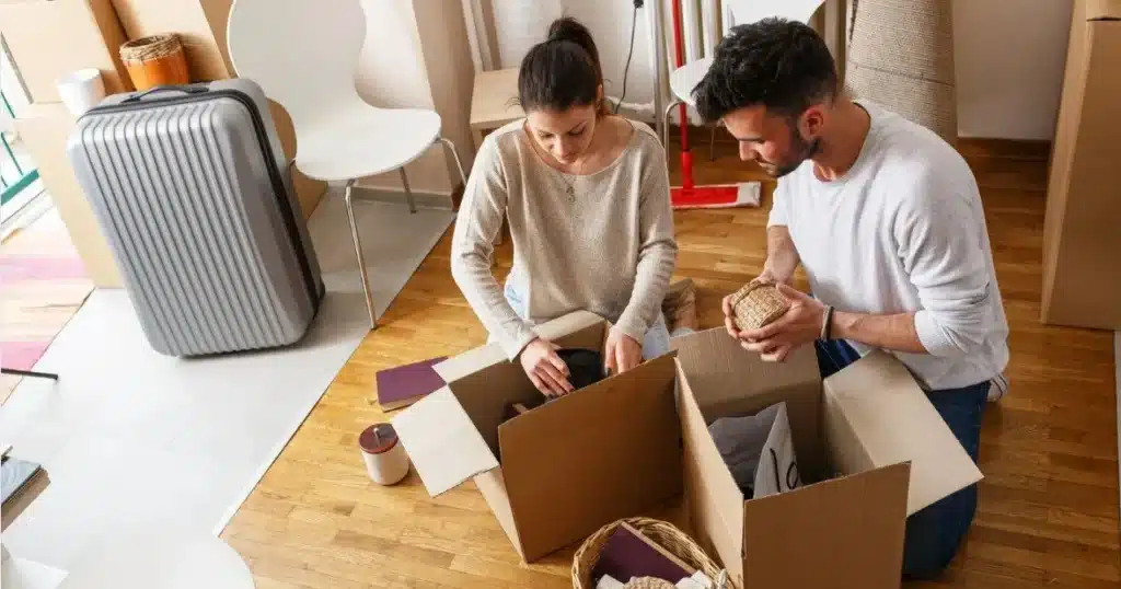 moving-to-calgary-from-another-province-what-matco-s-long-distance-movers-want-you-to-know1 Couple packing boxes in living room, preparing to move, surrounded by luggage and household items on wooden floor. | Sky Rye Design Couple packing boxes in living room, preparing to move, surrounded by luggage and household items on wooden floor.