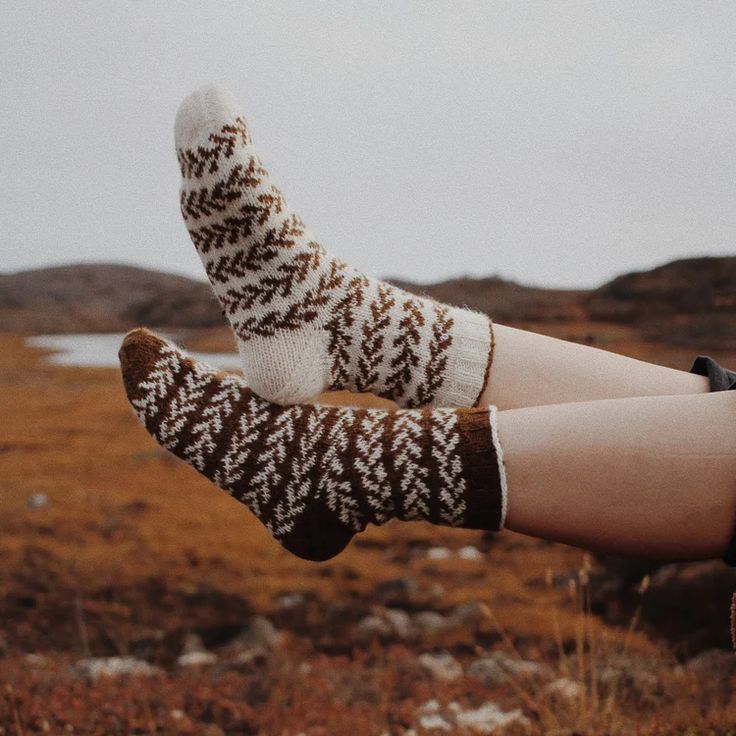 Cozy knitted socks with brown and white pattern in outdoor autumn setting. Perfect for warmth and style.