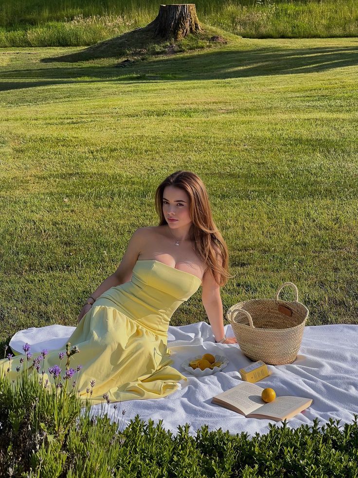 paulina_soltys on instagram for more inspiration Young woman in a yellow dress enjoying a sunny picnic on a grassy field with a basket and book. | Sky Rye Design Young woman in a yellow dress enjoying a sunny picnic on a grassy field with a basket and book.