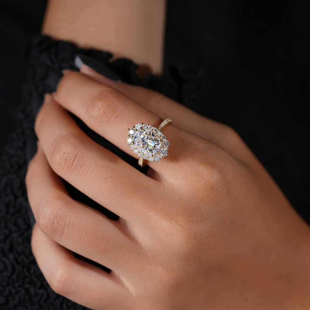 pexels-the-glorious-studio-3584518-32652449 Elegant hand wearing a sparkling oval diamond engagement ring with a gold band. | Sky Rye Design Elegant hand wearing a sparkling oval diamond engagement ring with a gold band.