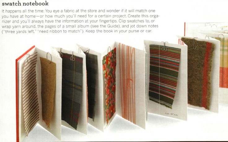 Fabric swatch notebook with multiple patterns clipped inside, ideal for matching fabrics and organizing sewing projects.