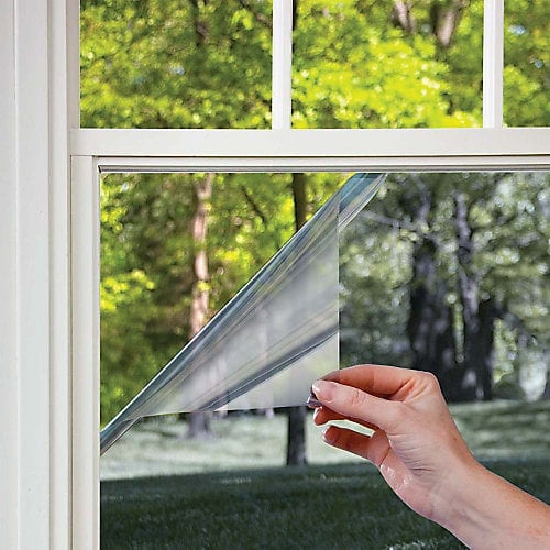 two-way-mirror-window-film Hand applying clear window film with scenic garden background. Energy efficient home solution. | Sky Rye Design Hand applying clear window film with scenic garden background. Energy efficient home solution.