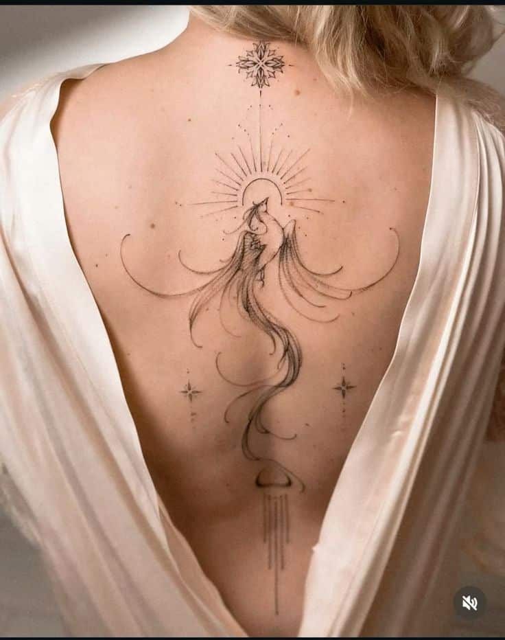 _ Elegant back tattoo with abstract celestial design and flowing lines, displayed on a woman's back in a white dress. | Sky Rye Design Elegant back tattoo with abstract celestial design and flowing lines, displayed on a woman's back in a white dress.