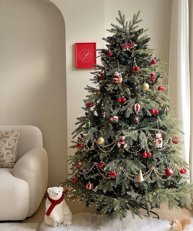 Decorated Christmas tree with red and gold ornaments in cozy living room, beside a plush polar bear. Christmas tree