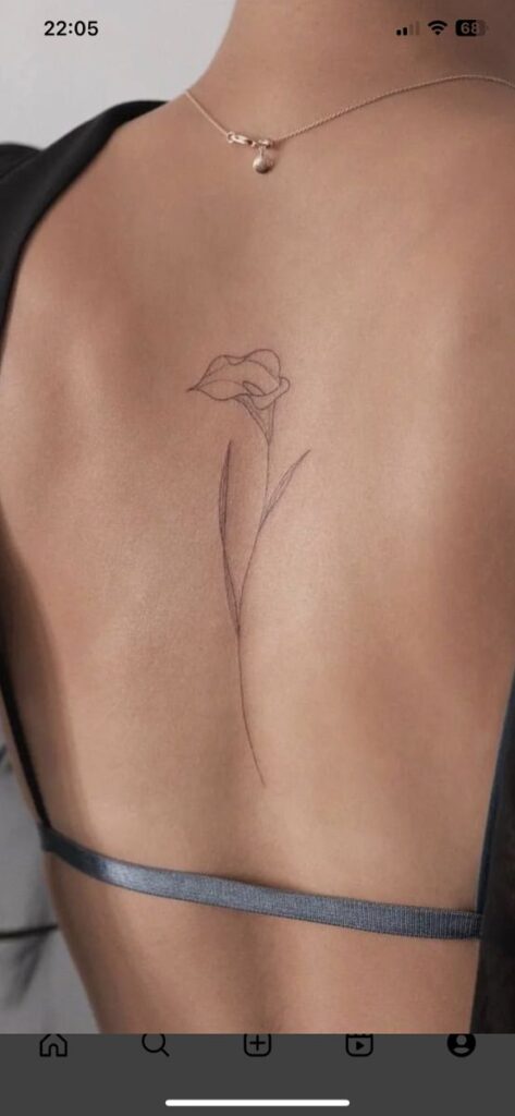 Minimalist flower tattoo on a woman's back, symbolizing elegance and simplicity in body art design. Flower tattoos