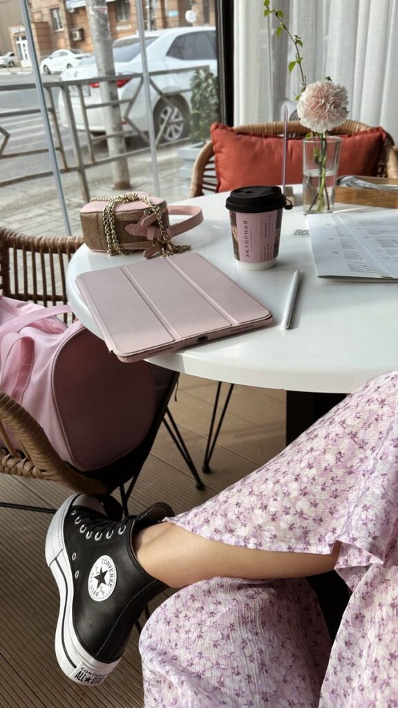Эстетика утра Cozy café setup with coffee, tablet, floral dress, and sneakers, perfect for a relaxing work session. | Sky Rye Design Cozy café setup with coffee, tablet, floral dress, and sneakers, perfect for a relaxing work session.
