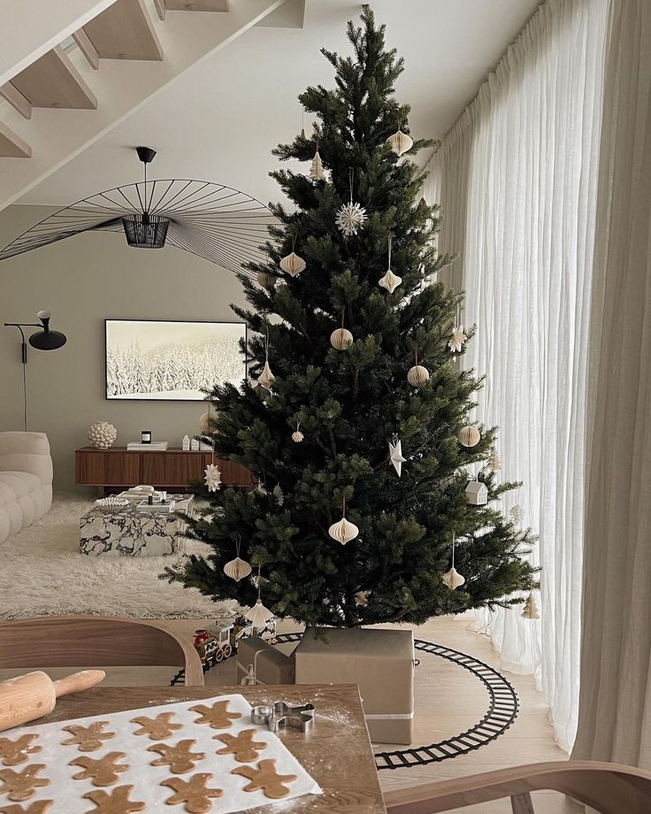 ⚡️🤍 Modern living room with decorated Christmas tree, festive gingerbread cookies on table, and cozy decor accents. | Sky Rye Design Modern living room with decorated Christmas tree, festive gingerbread cookies on table, and cozy decor accents.