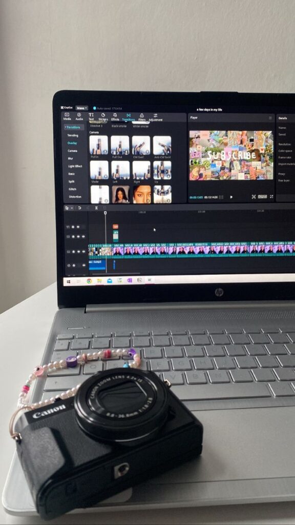 Laptop with video editing software and camera on desk, highlighting digital media creation.