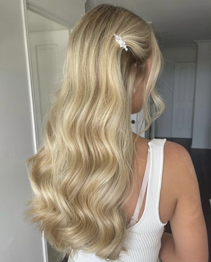 Blonde wavy hair with a decorative clip, styled for a casual look. Perfect for hair inspirations and beauty tips.