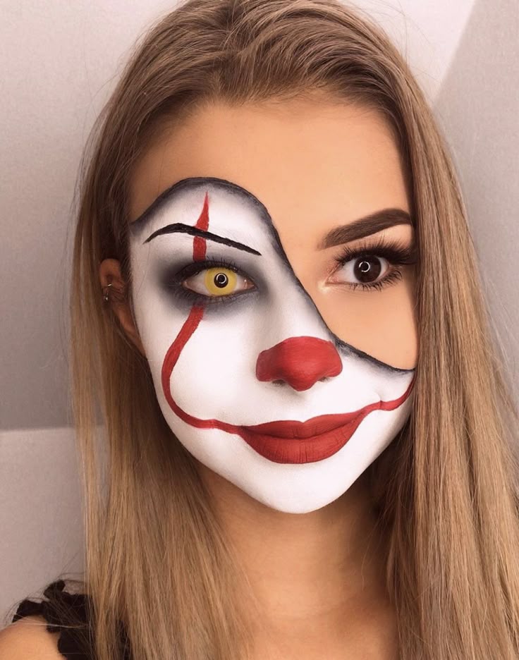Woman with half clown makeup, featuring red lips, white face, and yellow contact lens for Halloween.