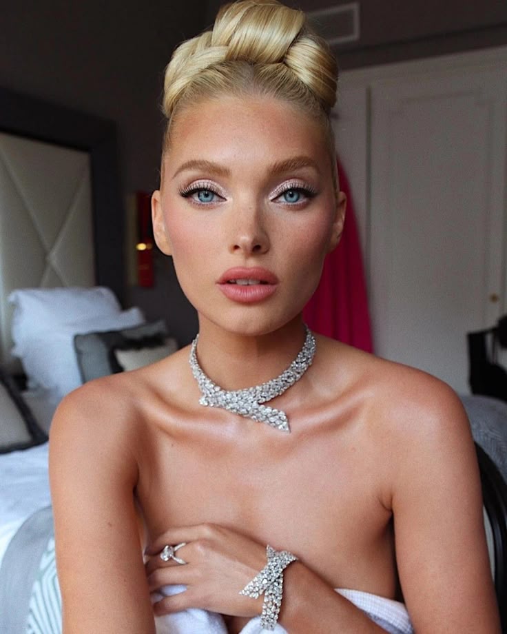 🥰 Elegant woman with braided updo and sparkling jewelry in a stylish room. | Sky Rye Design Elegant woman with braided updo and sparkling jewelry in a stylish room.