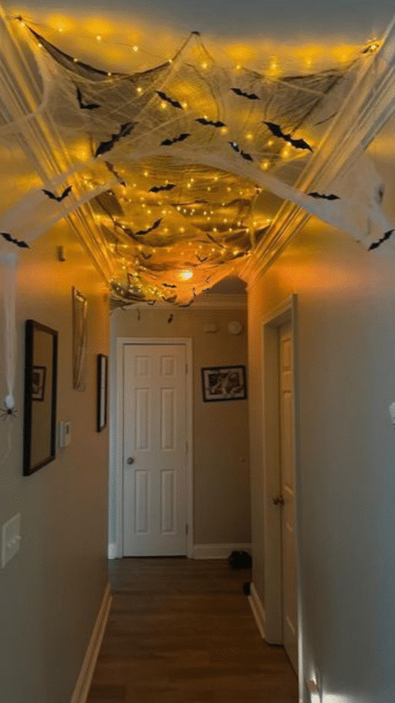 завантаження 23 Hallway with Halloween decor: spider webs, bats, and orange string lights create a spooky atmosphere. | Sky Rye Design Hallway with Halloween decor: spider webs, bats, and orange string lights create a spooky atmosphere.