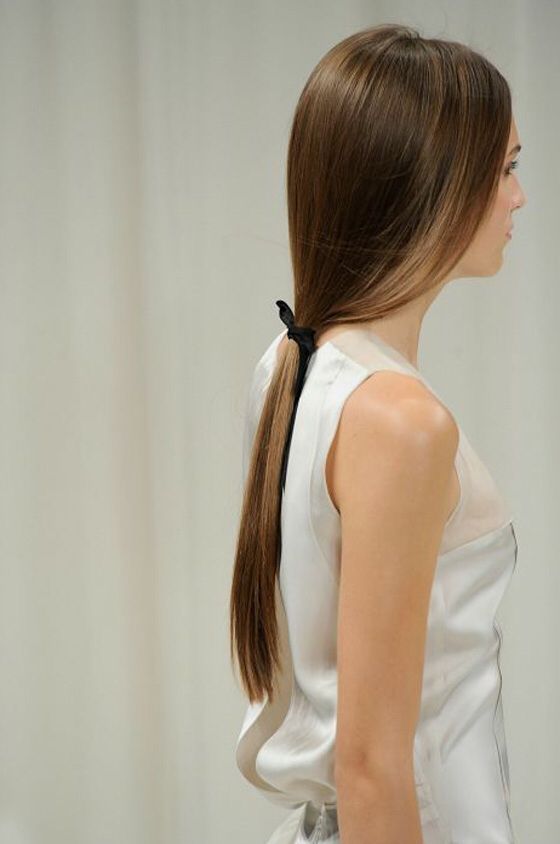 ا Side view of woman with sleek, long brown hair in low ponytail, wearing a white satin top. | Sky Rye Design Side view of woman with sleek, long brown hair in low ponytail, wearing a white satin top.