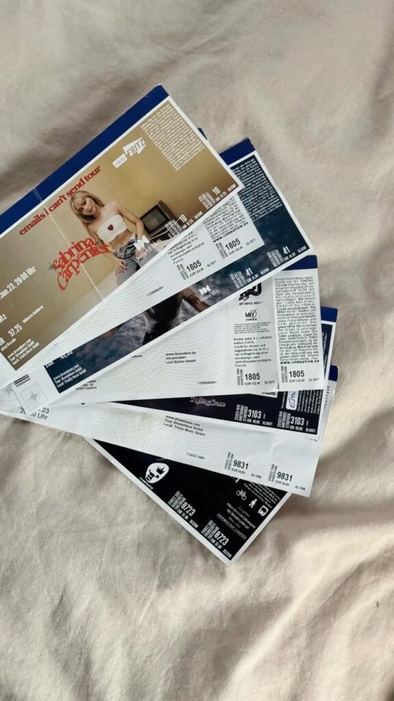 Concert tickets on a beige surface for an upcoming live music event.