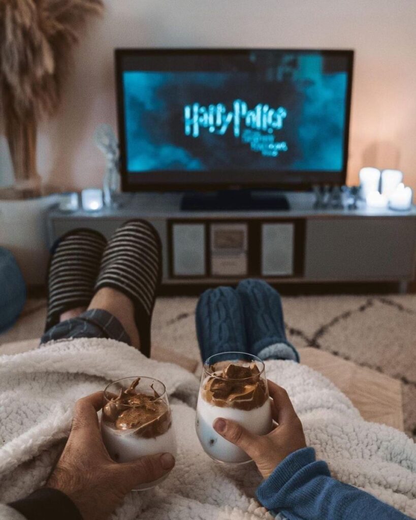 Cozy movie night with dalgona coffee, fluffy blankets, and warm slippers in front of the TV.