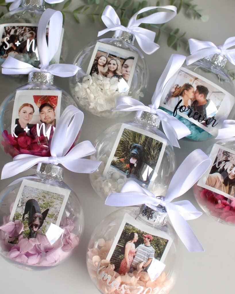 Personalized photo ornaments with white bows and flower petals for festive holiday decoration.