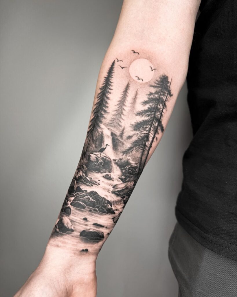 Tattoo of forest landscape with trees, waterfall, and birds on forearm, symbolizing nature and tranquility.