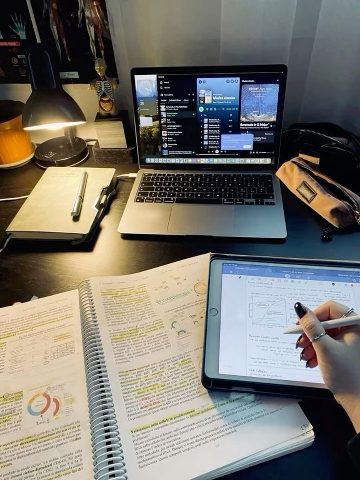 095125b6-afb1-4526-a128-c1febbe963a5 Student studying with books and digital tablet, laptop playing music, well-organized desk with lamp. | Sky Rye Design Student studying with books and digital tablet, laptop playing music, well-organized desk with lamp.