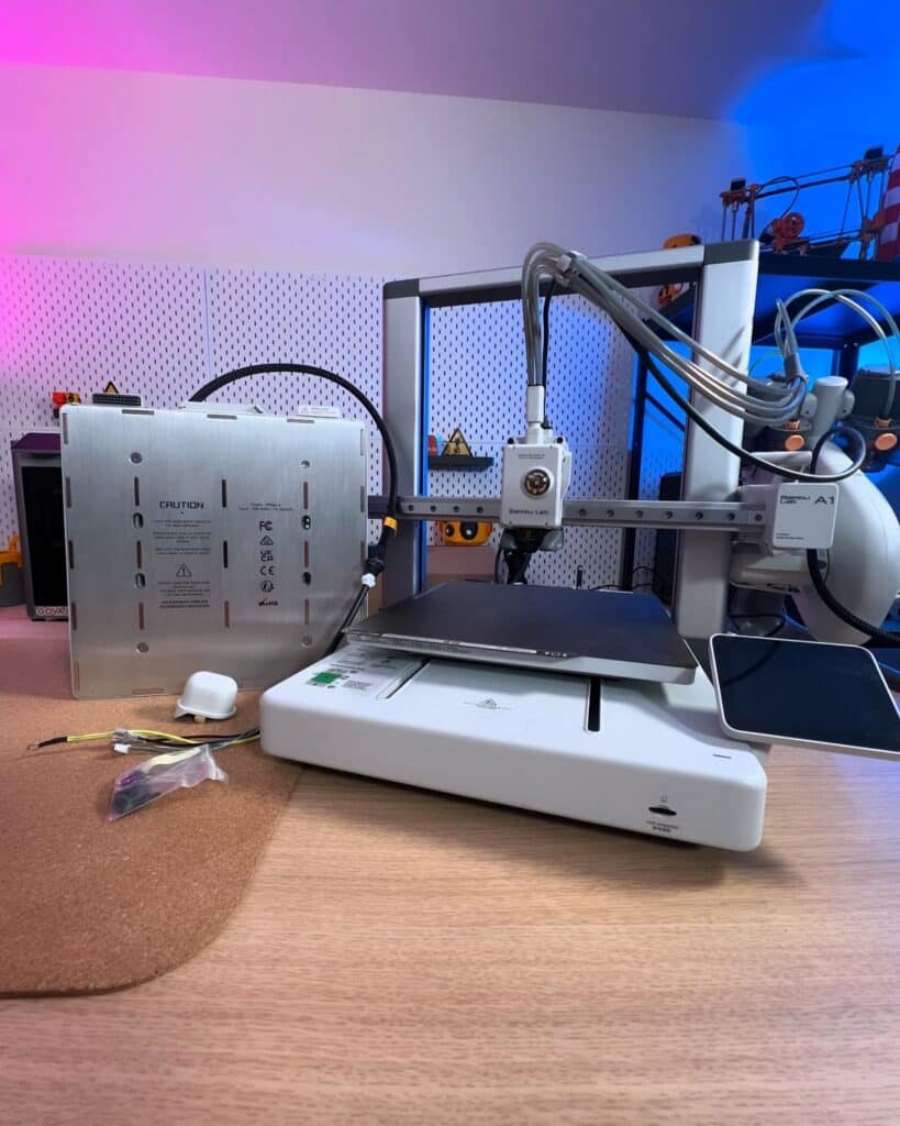 0cb35a2447151e5c939c4944a032f08e 1 3D printer setup on a desk with colorful lighting, showcasing its components and assembly parts. | Sky Rye Design 3D printer setup on a desk with colorful lighting, showcasing its components and assembly parts.