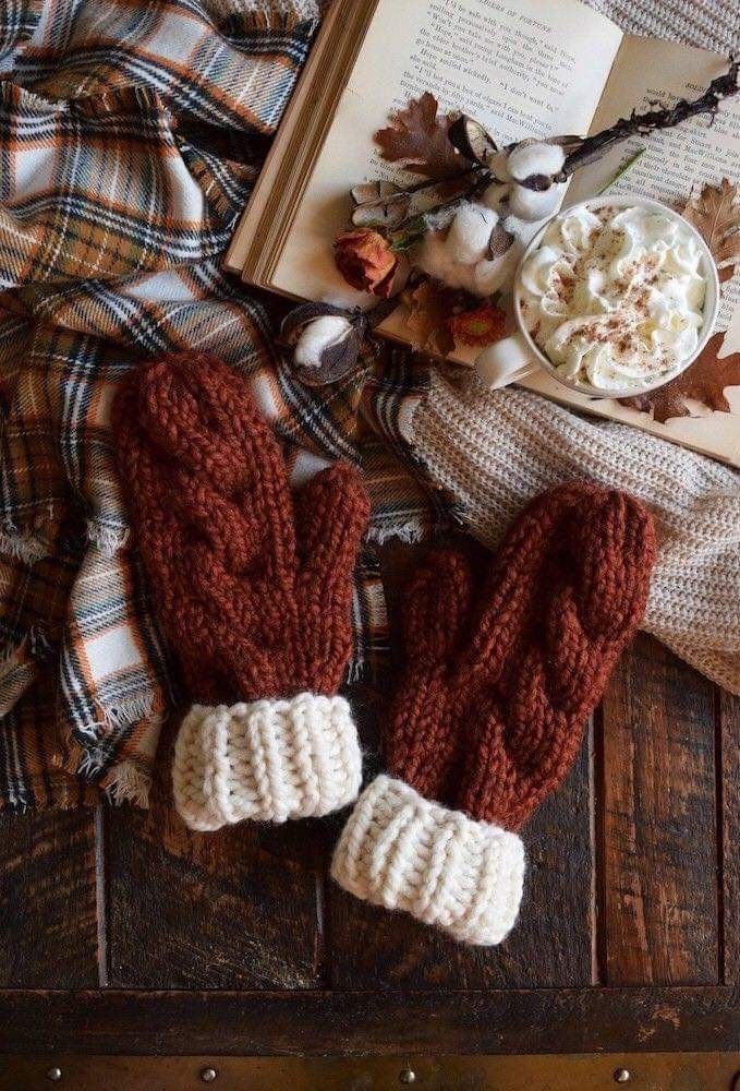 0fed1f04-b99b-431e-96e3-c85f5f3478be Cozy autumn scene with brown knit mittens, plaid blanket, open book, and whipped cream-topped hot drink on a wooden table. | Sky Rye Design Cozy autumn scene with brown knit mittens, plaid blanket, open book, and whipped cream-topped hot drink on a wooden table.